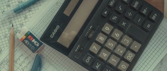 a calculator sitting on top of a pile of papers